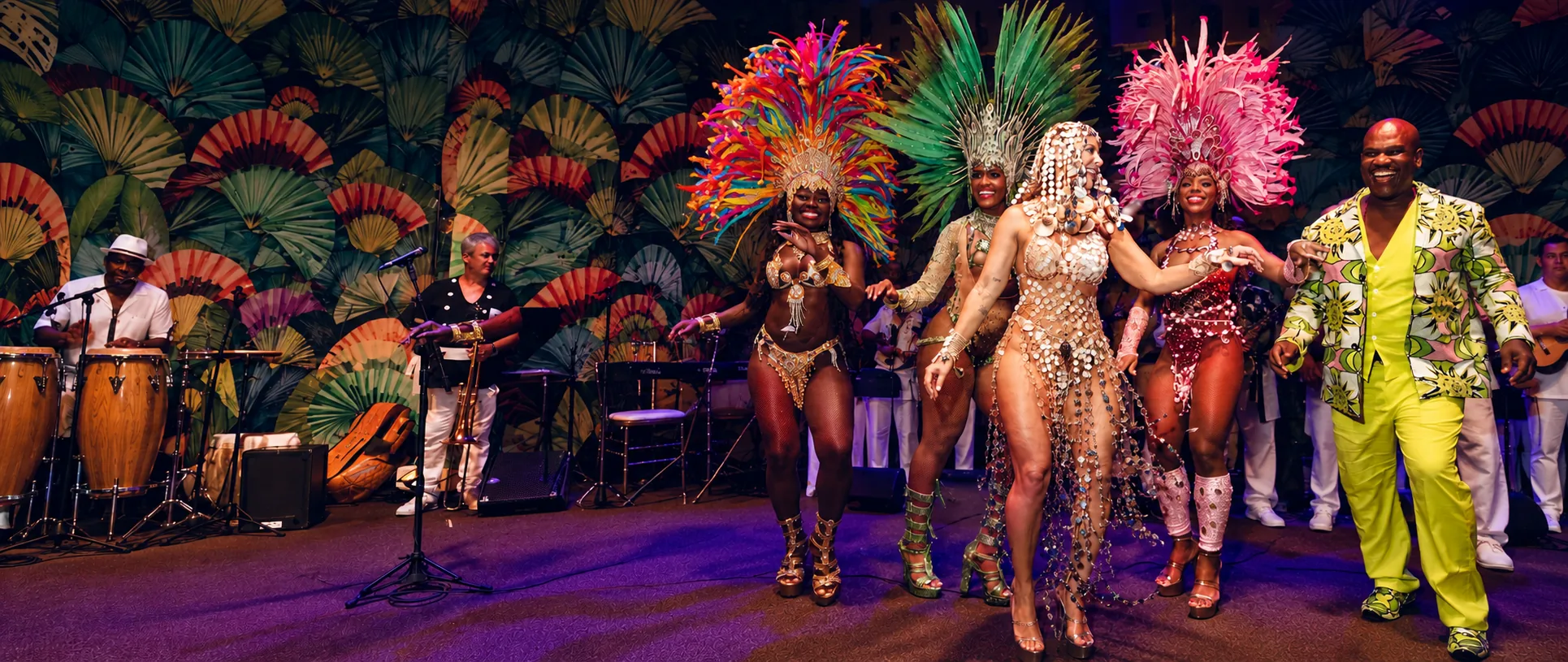Costumed samba dancers and the Copa Ball queen in a jeweled sash performing on stage with the live band at the Copacabana Palace