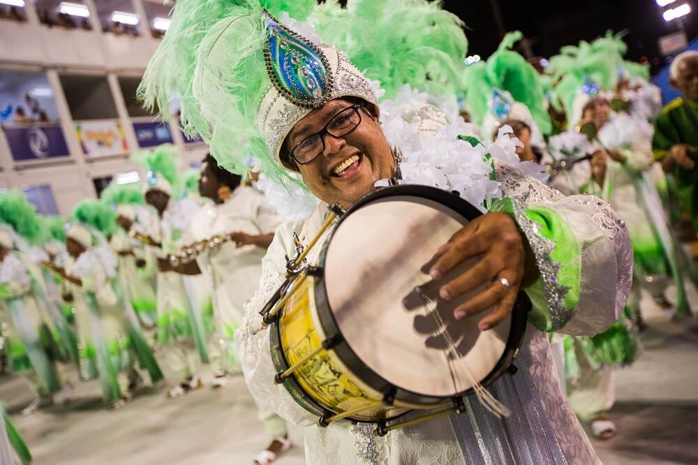 Ritmista tocando cuíca no carnaval do Rio