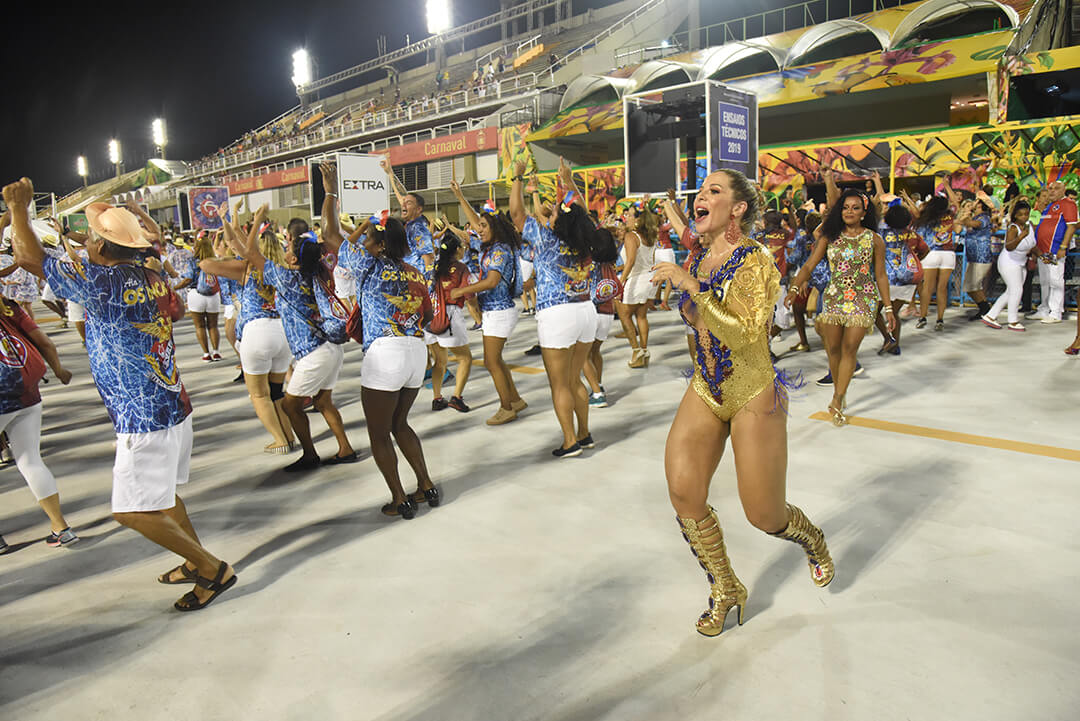 Mulher feliz no ensaio técnico do carnaval do Rio